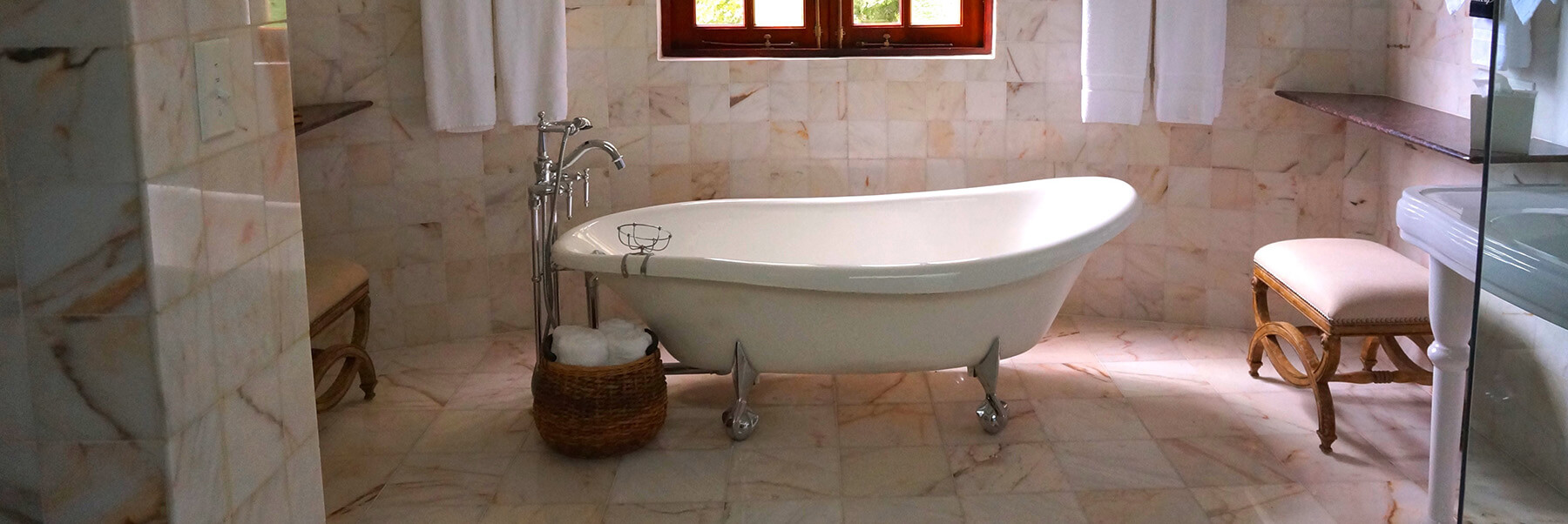 white tub in bathroom with tan tiles